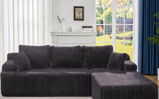 Dark grey corduroy sectional sofa by a garden window