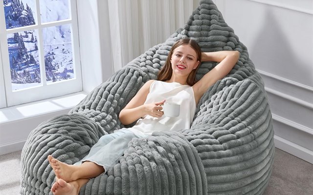 Grey bean bag chair by a window with a snowy view